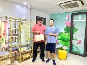 Khách hàng nước ngoài nhận túi quà khăn lụa vẽ tay SenSilk tại showroom